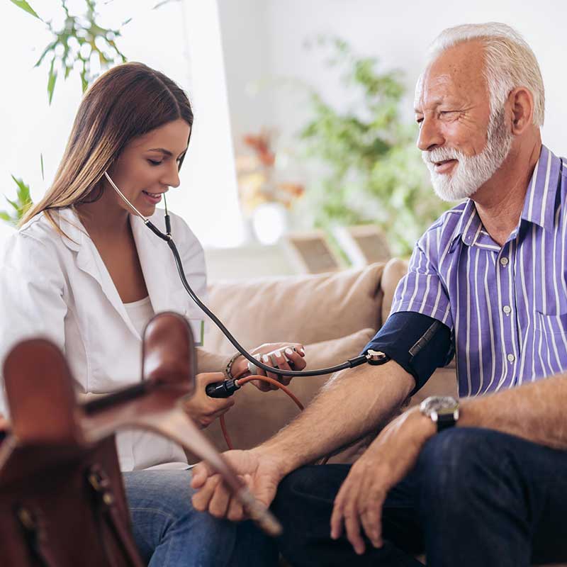 nurse-checking-blood-pressure-of-senior-man-in-home-cls-and-respite-care-services-integrated-living